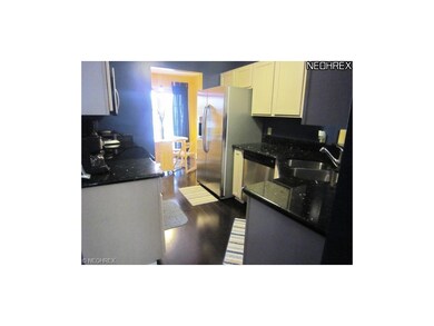 Kitchen features wood floors, stainless appliances