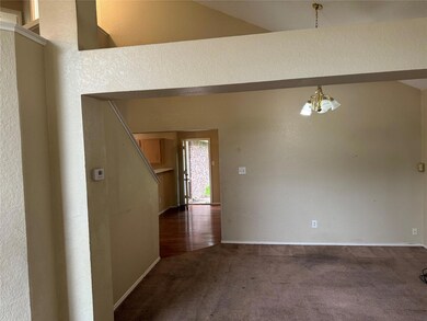 Carpeted empty room with lofted ceiling and a chan