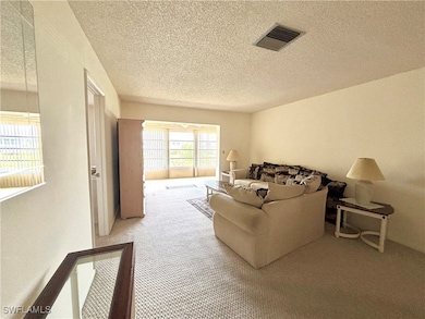 Living area with carpet floors, visible vents, and