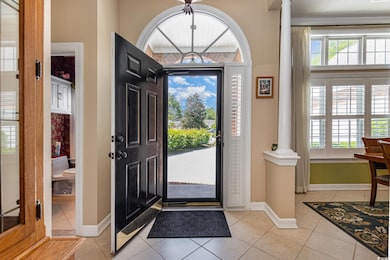 Entryway featuring decorative columns, light tile patterned floors, and plenty of natural light