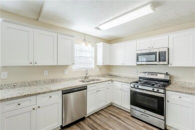 Kitchen with light wood finished floors, white cab