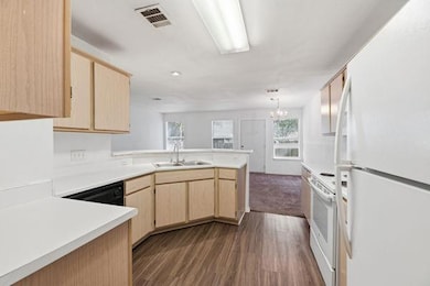 Kitchen with light brown cabinets, white applianc