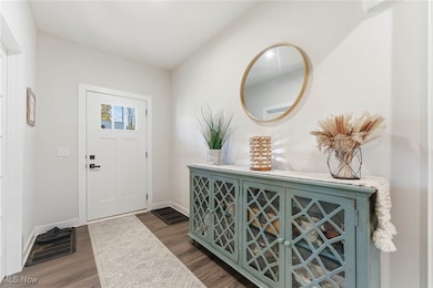 Foyer entrance with dark wood-style flooring and an AC wall unit