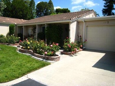 Rose flower beds surround the front door.  