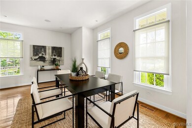 Dining room with visible vents, wood finished floo