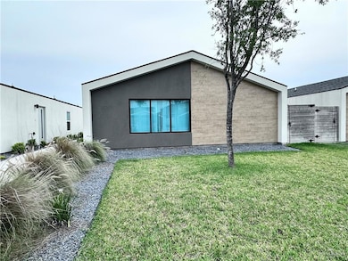 Back of house with stucco siding and a yard