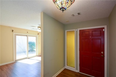 Entrance foyer with a textured ceiling, baseboards