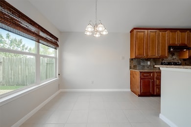 This bright dining area boasts large windows, offering a view of the backyard.