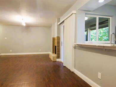Spare room with sink, a tiled fireplace, and dark 
