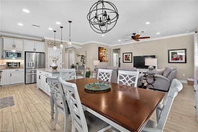 Dining space with wood tiled floors, ornamental molding, arched walkways, a chandelier, and recessed lighting