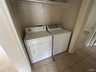 Washroom featuring washing machine and dryer and light tile patterned floors