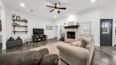 Living room with ceiling fan, crown molding, and a fireplace