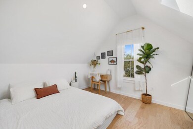 Bedroom with light wood-style floors, vaulted ceiling, recessed lighting, and a skylight