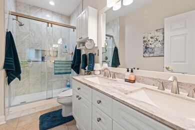 Full bath featuring double vanity, a shower stall, and tile patterned floors