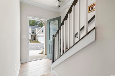 Foyer with baseboards, stairs, and wood finished f