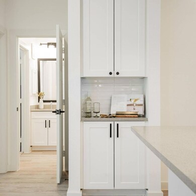 Bar featuring tasteful backsplash and white cabine