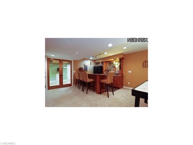 Finished basement with wet bar featuring granite t