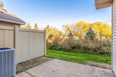 Enjoy peaceful outdoor moments on the private patio, bordered by greenery for added privacy and comfort.