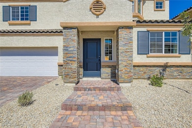View of exterior entry with stone siding, stucco s