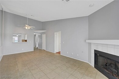 Unfurnished living room featuring light tile patterned floors, a fireplace, ceiling fan, and high vaulted ceiling