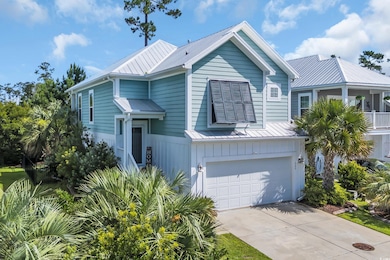 View of front of home featuring an attached garage, a metal roof, driveway, and a standing seam roof
