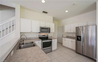 Kitchen featuring appliances with stainless steel finishes, white cabinetry, light countertops, light tile patterned floors, and recessed lighting