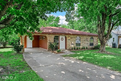 Ranch-style house featuring a front yard and a car