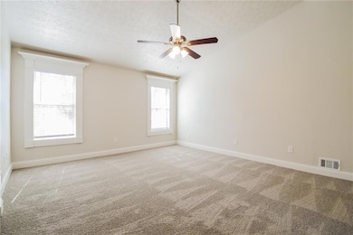 Spare room with visible vents, light carpet, a tex