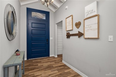 Foyer with vaulted ceiling, a chandelier, and dark hardwood / wood-style flooring