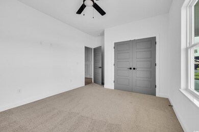Unfurnished bedroom featuring carpet floors, a closet, and ceiling fan