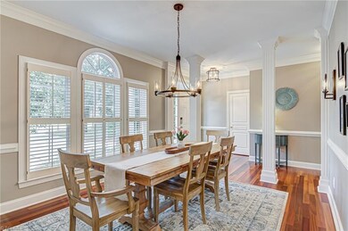 The dining room features engineered wood flooring, crown and chair rail moulding, and large windows for lots of natural light! Notice the updated light fixtures and plantation shutters.