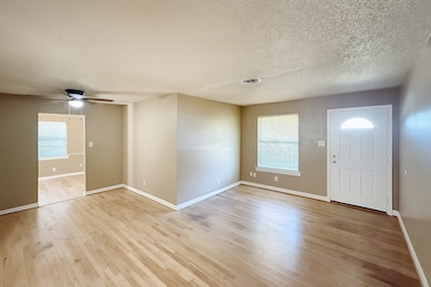 Entrance foyer featuring light wood-style floors, a textured ceiling, and a ceiling fan