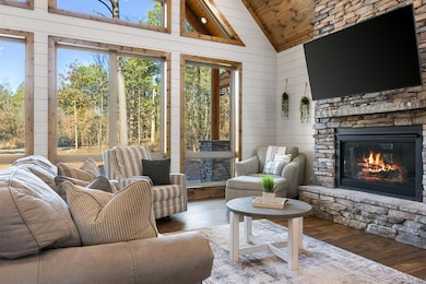 Sunroom / solarium featuring a fireplace, vaulted ceiling, and wood ceiling