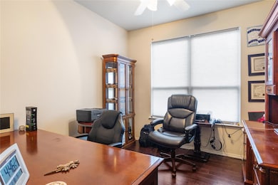 Office space with ceiling fan and dark hardwood / 