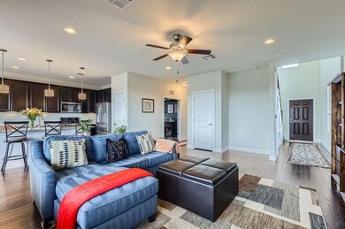 Living room with ceiling fan, light wood-style fl