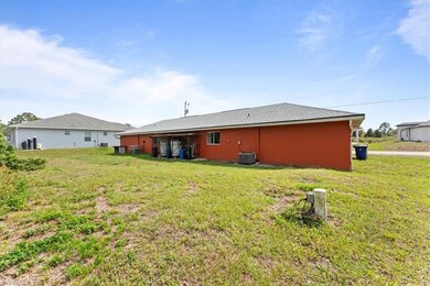 Back of property featuring a lawn and central air 
