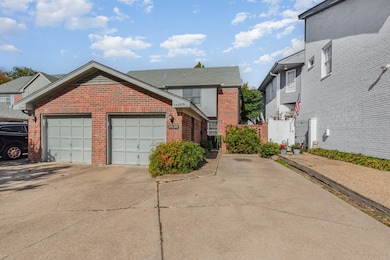 Traditional-style home featuring brick siding, concrete driveway, and a gate