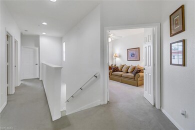 Hallway featuring light carpet