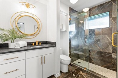 Bathroom with an enclosed shower, vanity, and toil