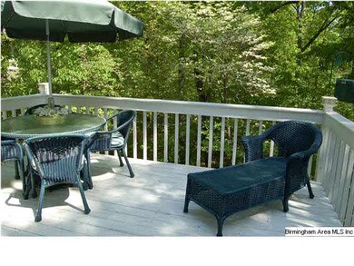 The back deck is surrounded by mature trees that p