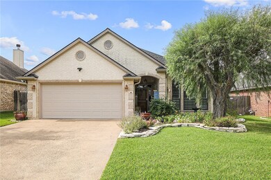 Ranch-style home featuring a garage and a front ya