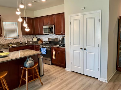 Kitchen featuring decorative light fixtures, stain