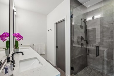 Upstairs, the Spacious Primary Suite feels like a High-End Hotel Escape, featuring a Wall of Windows, Large Walk-In Closet, and a Spa-Inspired Bathroom with Stone Double Vanity, Glass-Enclosed Shower, and Designer Finishes.