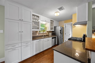 Kitchen with dark wood-type flooring, glass inser