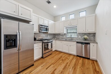 The well-equipped kitchen includes slab granite countertops, marble tile backsplash, stainless-steel double basin undermount sink, and stainless-steel GE appliances that including a gas range. The window over the sink with custom blinds and 3 transom windows provides tons of natural light.

