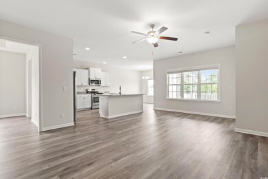 Unfurnished living room with a ceiling fan, dark wood finished floors, recessed lighting, baseboards, and a chandelier