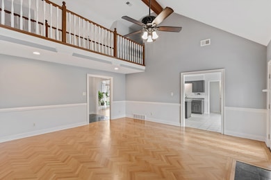 Unfurnished living room featuring high vaulted cei