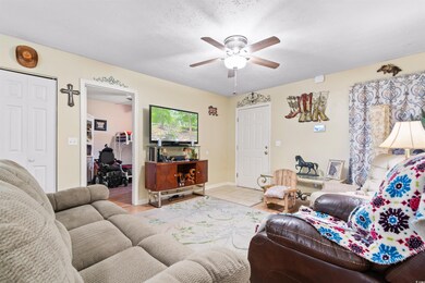 Living room with a textured ceiling, light tile pa
