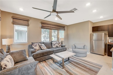 Living room with visible vents, ceiling fan, and r