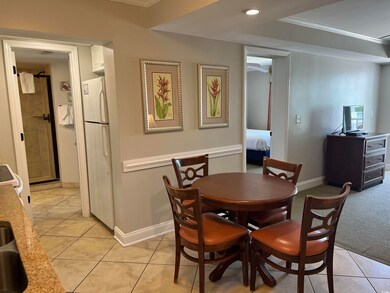Carpeted dining space with crown molding
